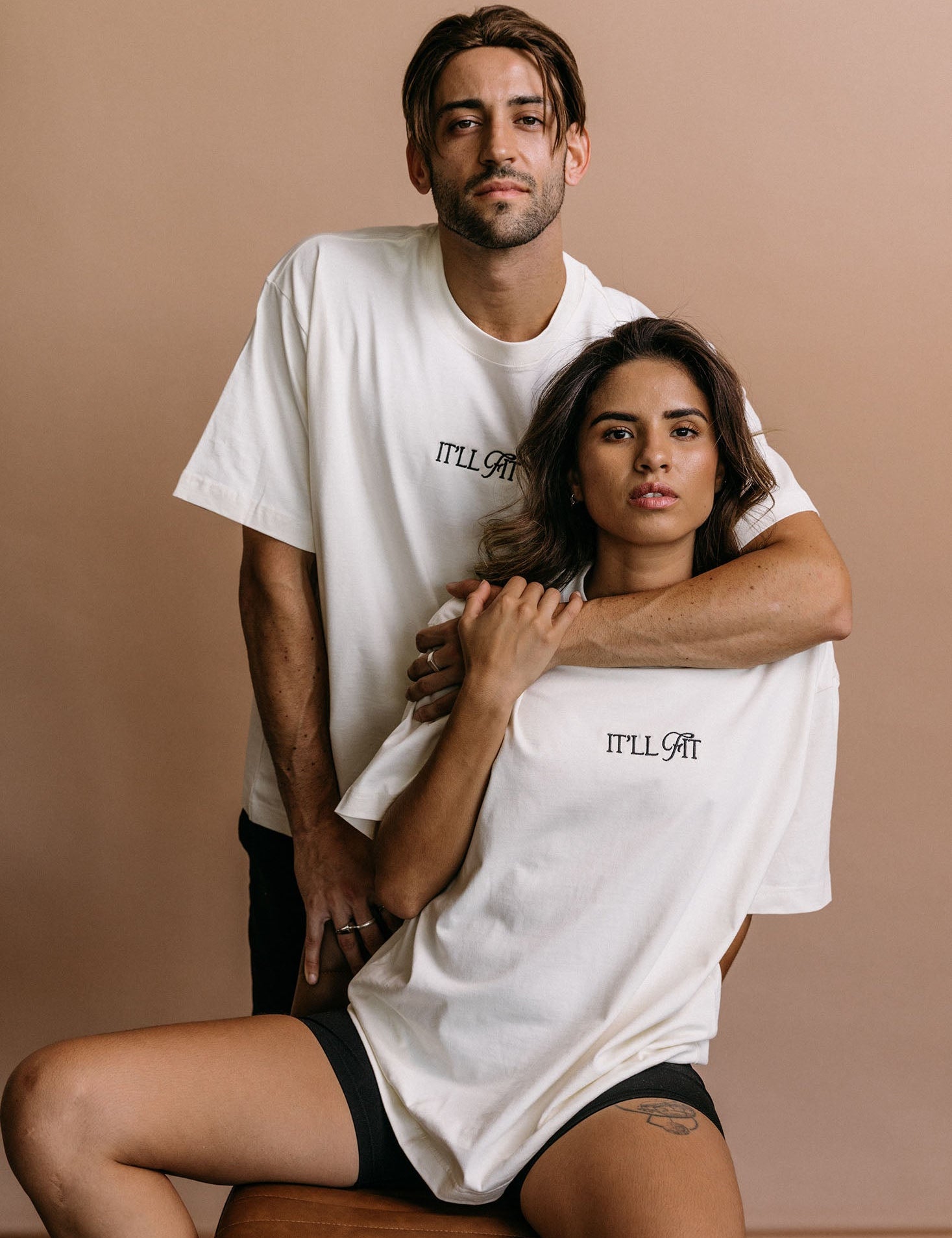 Couple wearing WNGSPN relaxed fit embroidered tees featuring bold quote designs in a relaxed, intimate setting