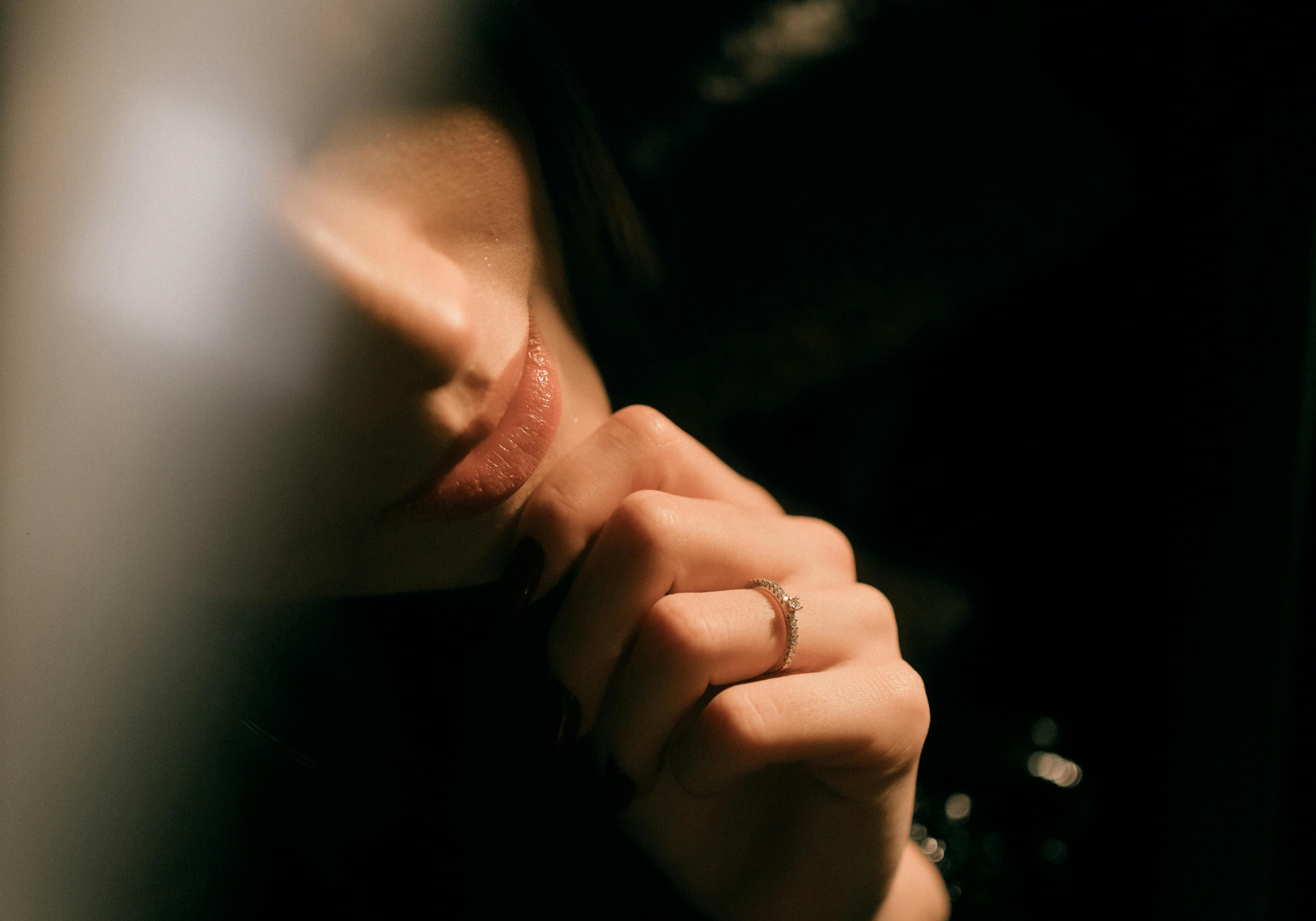 Close-up of lips and hand in a quiet, intimate moment representing desire, anticipation, and emotional tension in WNGSPN