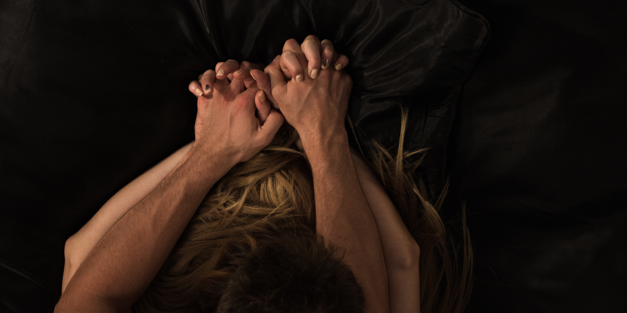 Hands intertwined in a tense, intimate moment representing romance tropes, desire, and connection in WNGSPN