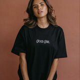 Female model wearing the black "Good Girl" relaxed fit embroidered T-shirt by WNGSPN, with a relaxed silhouette and clean lines.