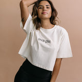Female model wearing the ecru "Good Girl" cropped embroidered T-shirt by WNGSPN, with a relaxed silhouette and clean lines.