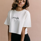 Female model wearing the ecru "Good Girl" cropped embroidered T-shirt by WNGSPN, with a relaxed silhouette and clean lines.