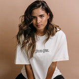 Female model wearing the ecru "Good Girl" relaxed fit embroidered T-shirt by WNGSPN, styled with understated confidence.
