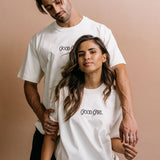 Couple wearing the ecru "Good Girl" relaxed fit embroidered T-shirt by WNGSPN, capturing a refined bookish aesthetic.