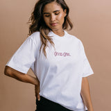 Female model wearing the white "Good Girl" relaxed fit embroidered T-shirt by WNGSPN, styled in a minimal, elevated aesthetic.
