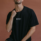 Male model wearing the black "Iicyify" relaxed fit embroidered T-shirt by WNGSPN, styled with understated confidence.