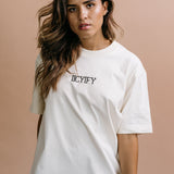 Female model wearing the ecru "Iicyify" relaxed fit embroidered T-shirt by WNGSPN, styled in a minimal, elevated aesthetic.