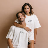 Couple wearing the ecru "Iicyify" relaxed fit embroidered T-shirt by WNGSPN, capturing a refined bookish aesthetic.