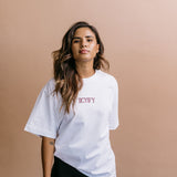Female model wearing the white "Iicyify" relaxed fit embroidered T-shirt by WNGSPN, with a relaxed silhouette and clean lines.
