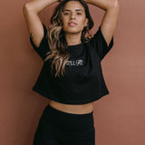 Female model wearing the black "It'll Fit" cropped embroidered T-shirt by WNGSPN, styled with understated confidence.