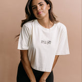 Female model wearing the ecru "It'll Fit" cropped embroidered T-shirt by WNGSPN, with a relaxed silhouette and clean lines.