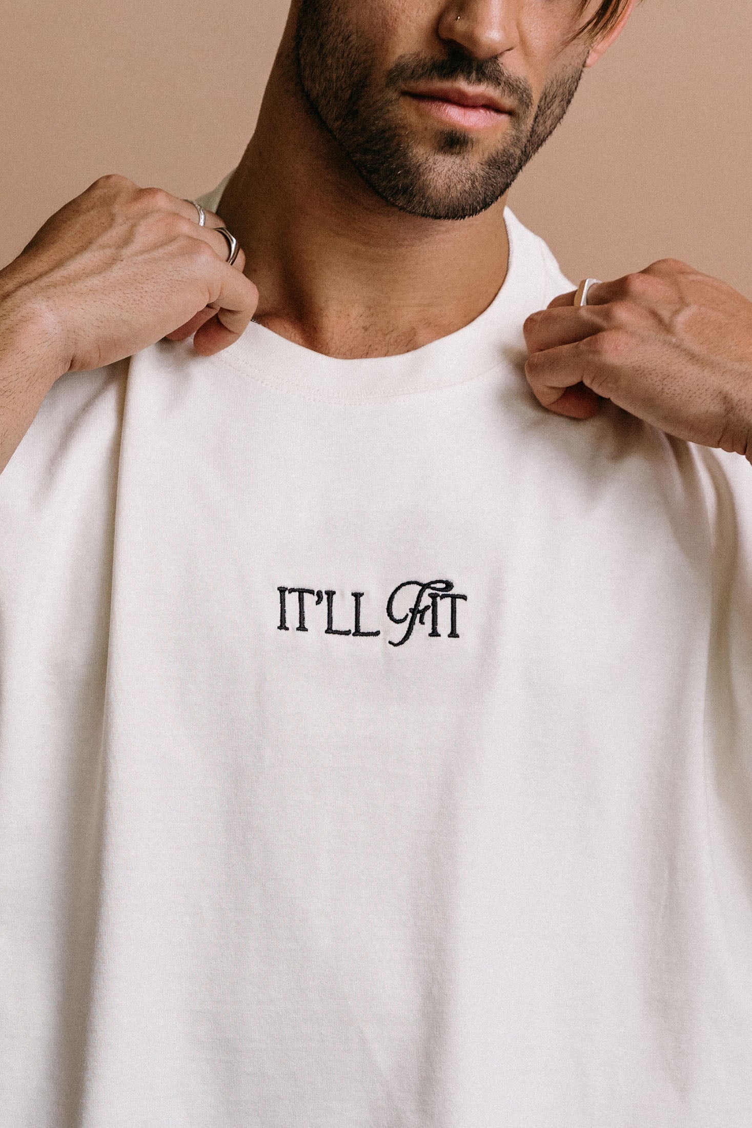 Close-up embroidery detail of the "It'll Fit" relaxed fit T-shirt by WNGSPN, highlighting clean, minimalist embroidery.