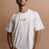 Male model wearing the ecru "It'll Fit" relaxed fit embroidered T-shirt by WNGSPN, styled in a minimal, elevated aesthetic.