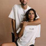 Couple wearing the ecru "It'll Fit" relaxed fit embroidered T-shirt by WNGSPN, capturing a refined bookish aesthetic.