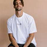 Female model wearing the white "It'll Fit" relaxed fit embroidered T-shirt by WNGSPN, with a relaxed silhouette and clean lines.