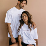 Couple wearing the white "It'll Fit" relaxed fit embroidered T-shirt by WNGSPN, with subtle tension and modern edge.