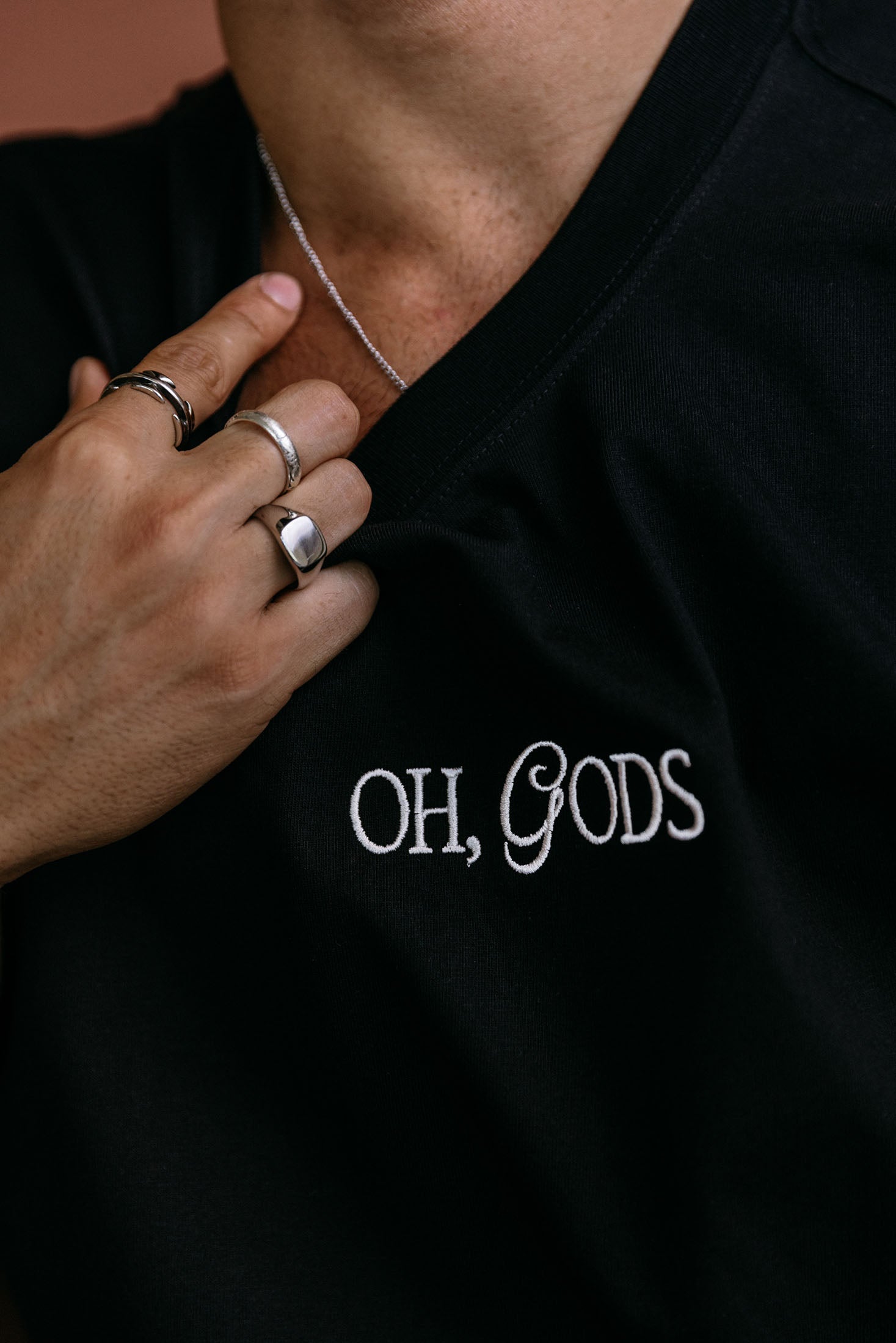 Close-up embroidery detail of the "Oh Gods" relaxed fit T-shirt by WNGSPN, highlighting clean, minimalist embroidery.