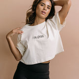 Female model wearing the ecru "Oh Gods" cropped embroidered T-shirt by WNGSPN, with a relaxed silhouette and clean lines.