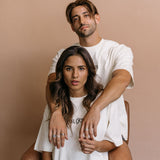 Couple wearing the ecru "Oh Gods" relaxed fit embroidered T-shirt by WNGSPN, capturing a refined bookish aesthetic.