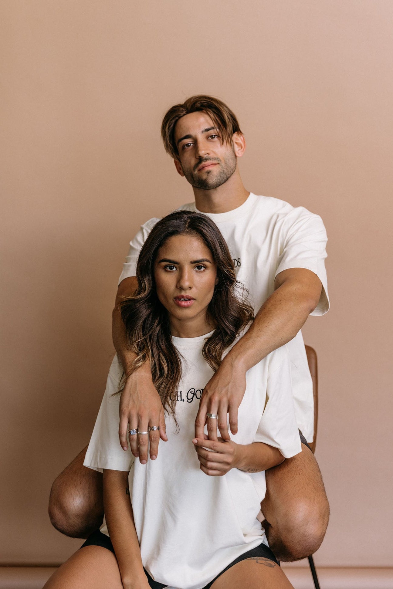 Couple wearing the ecru "Oh Gods" relaxed fit embroidered T-shirt by WNGSPN, capturing a refined bookish aesthetic.