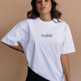 Female model wearing the white "Oh Gods" relaxed fit embroidered T-shirt by WNGSPN, with a relaxed silhouette and clean lines.