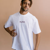 Male model wearing the white "Oh Gods" relaxed fit embroidered T-shirt by WNGSPN, with a relaxed silhouette and clean lines.