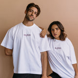 Couple wearing the white "Oh Gods" relaxed fit embroidered T-shirt by WNGSPN, with subtle tension and modern edge.