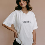 Female model wearing the ecru "There She Is" relaxed fit embroidered T-shirt by WNGSPN, styled in a minimal, elevated aesthetic.