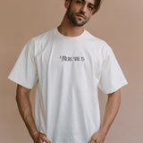 Male model wearing the ecru "There She Is" relaxed fit embroidered T-shirt by WNGSPN, styled in a minimal, elevated aesthetic.