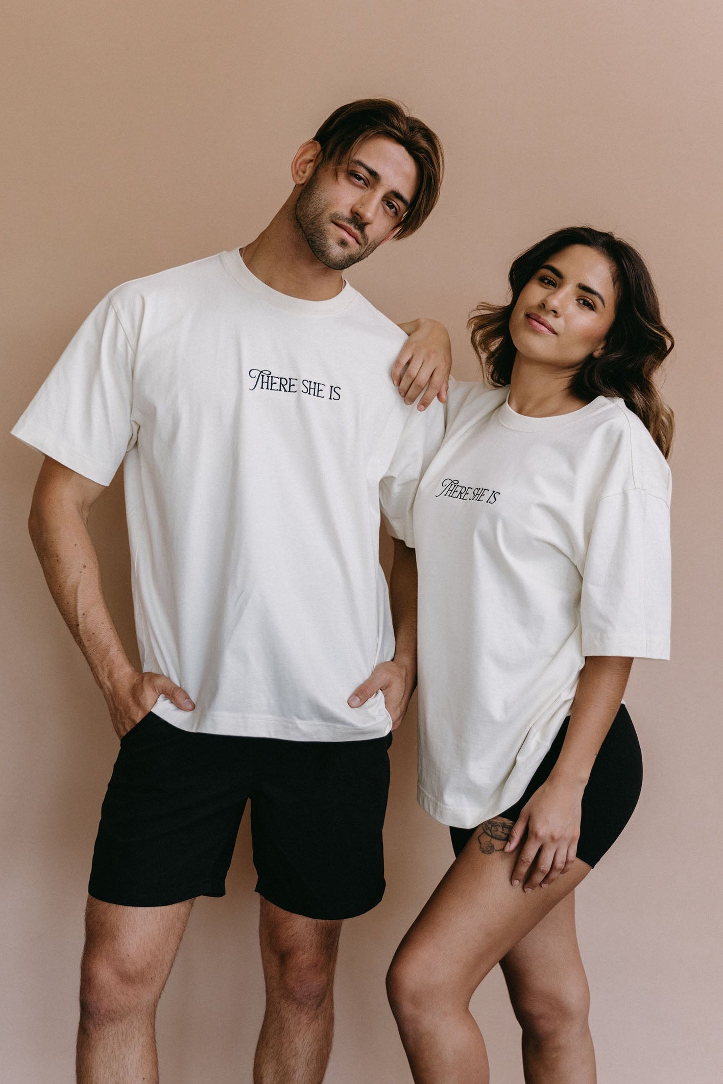 Couple wearing the ecru "There She Is" relaxed fit embroidered T-shirt by WNGSPN, capturing a refined bookish aesthetic.
