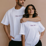 Couple wearing the white "There She Is" relaxed fit embroidered T-shirt by WNGSPN, with subtle tension and modern edge.