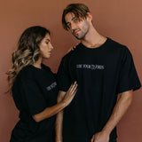 Couple wearing the black "Use Your Words" relaxed fit embroidered T-shirt by WNGSPN, styled as elevated romance reader apparel.