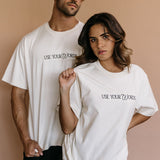 Couple wearing the ecru "Use Your Words" relaxed fit embroidered T-shirt by WNGSPN, capturing a refined bookish aesthetic.