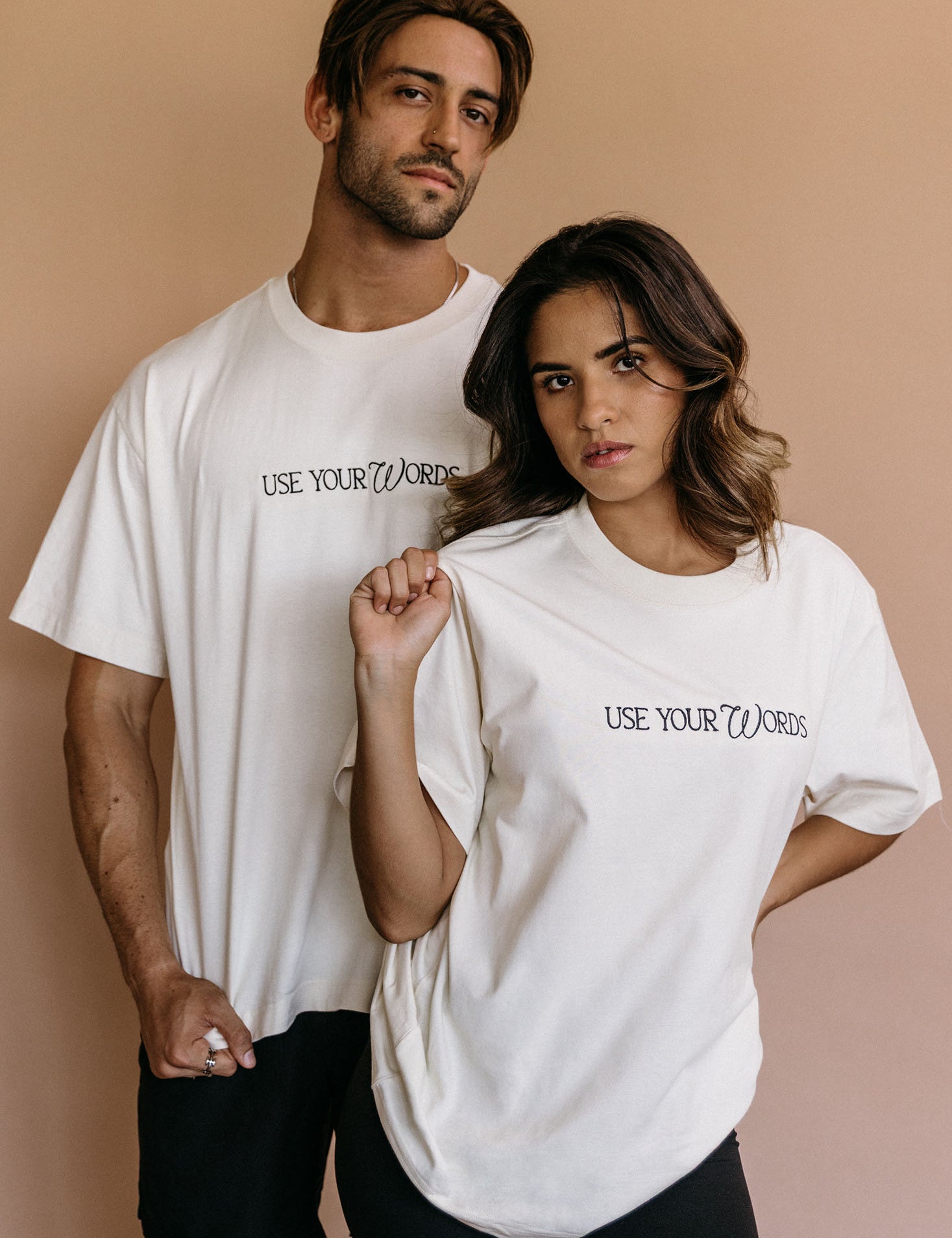Couple wearing the ecru "Use Your Words" relaxed fit embroidered T-shirt by WNGSPN, capturing a refined bookish aesthetic.