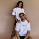 Couple wearing the white "Use Your Words" relaxed fit embroidered T-shirt by WNGSPN, with subtle tension and modern edge.