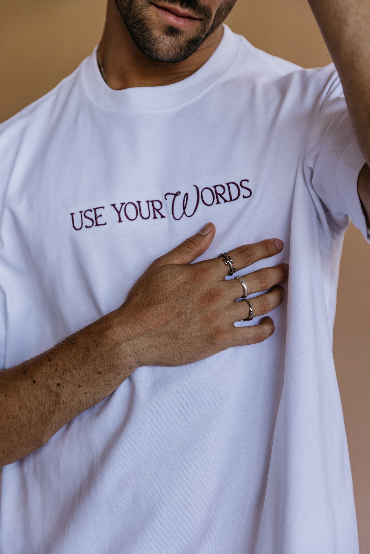 Close-up embroidery detail of the "Use Your Words" relaxed fit T-shirt by WNGSPN, highlighting clean, minimalist embroidery.