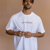 Male model wearing the white "Use Your Words" relaxed fit embroidered T-shirt by WNGSPN, with a relaxed silhouette and clean lines.