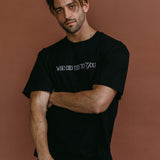 Male model wearing the black "Who Did This To You" relaxed fit embroidered T-shirt by WNGSPN, styled with understated confidence.