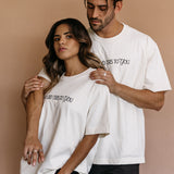 Couple wearing the ecru "Who Did This To You" relaxed fit embroidered T-shirt by WNGSPN, capturing a refined bookish aesthetic.