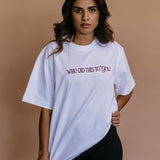 Female model wearing the ecru "Who Did This To You" relaxed fit embroidered T-shirt by WNGSPN, styled in a minimal, elevated aesthetic.