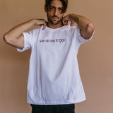 Male model wearing the white "Who Did This To You" relaxed fit embroidered T-shirt by WNGSPN, with a relaxed silhouette and clean lines.